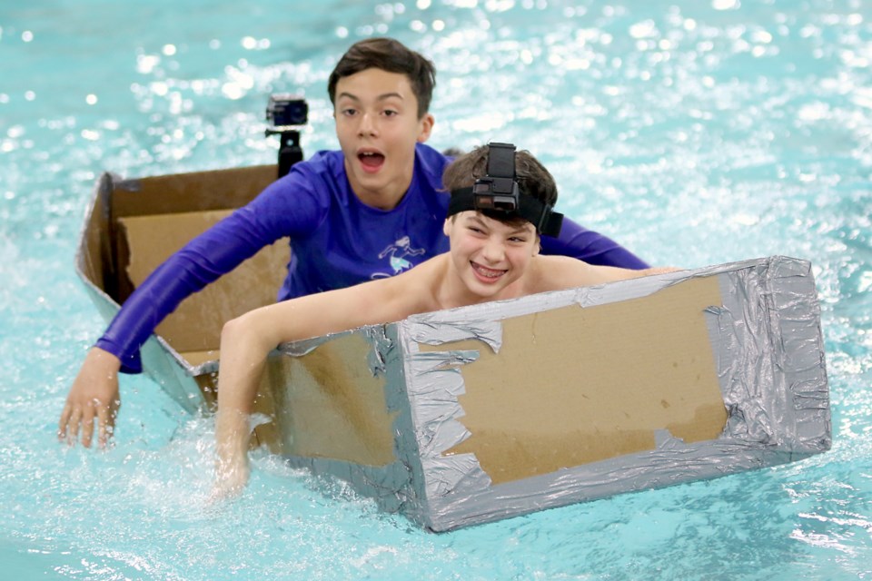 Woodcrest Public Schools students Lucas Christie, 12, and C.J. Tsekouras, 12, take part in the annual cardboard boat competition at the Churchill Pool on Tuesday, Nov. 19, 2019. (Leith Dunick, tbnewswatch.com)