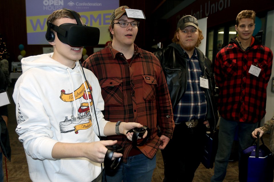 Evan Strilchuk (left) tests out virtual reality equipment during Confederation College's annual recruitment day. (Leith Dunick, tbnewswatch.com)