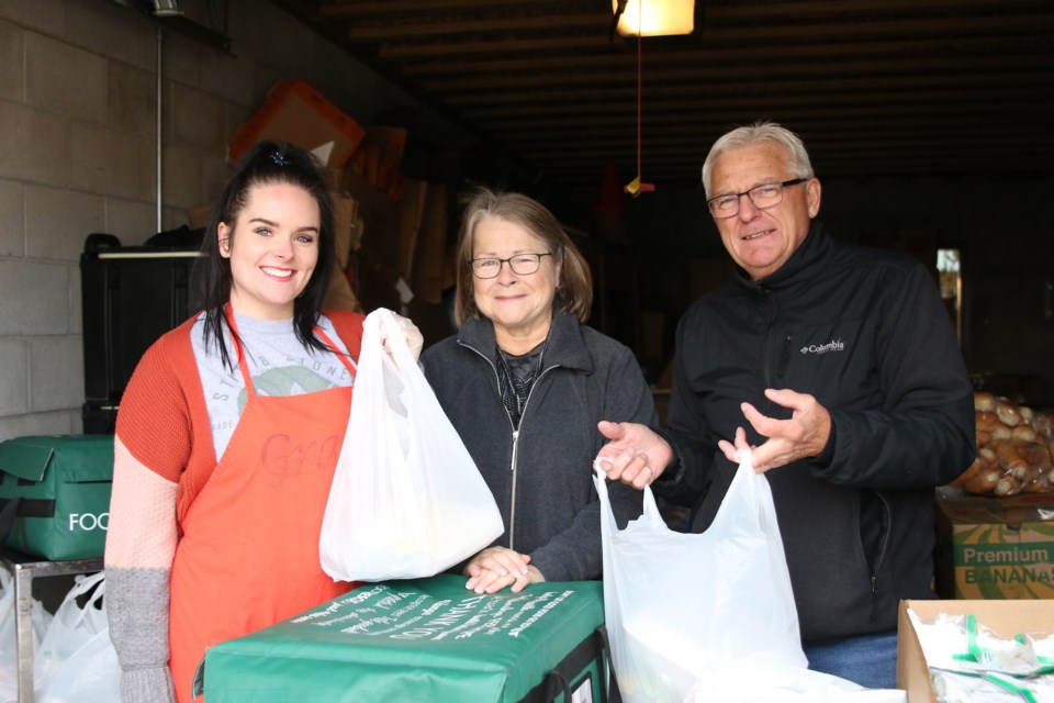 Kelsie Foy (left), Kathy O’Brien, and Terry O’Brien, volunteers with the Dew Drop Inn, were handing out to-go meals during the Thanksgiving dinner on Monday. (Photos by Doug Diaczuk - Tbnewswatch.com). 
