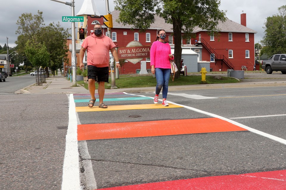 Thunder Pride chair Jason Veltri (left) and Northwood Coun. Shelby Ch'ng on Thursday, Aug. 20, 2020, walk across Algoma Street on the first of three rainbow crosswalks being installed on city streets. (Leith Dunick, tbnewswatch.com)