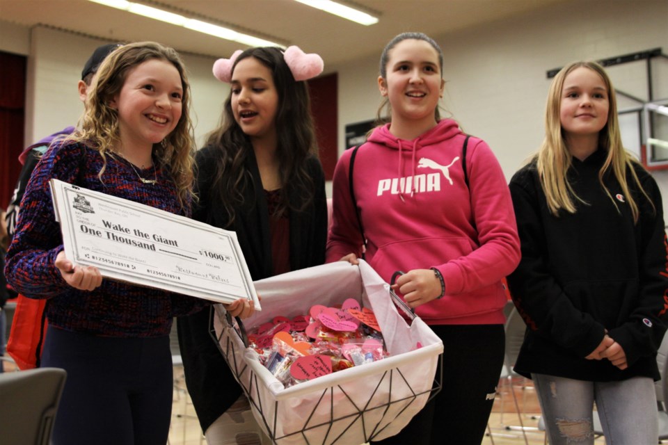 Westmount students (from left) Camryn Pereira, Jolie Whitecrow, Jersey Daniels-Wakefield, and Tykara Balke-Brewer deliver candygrams, along with a $1,000 cheque for Wake the Giant, at DFC Friday. (Photos by Ian Kaufman, tbnewswatch.com)