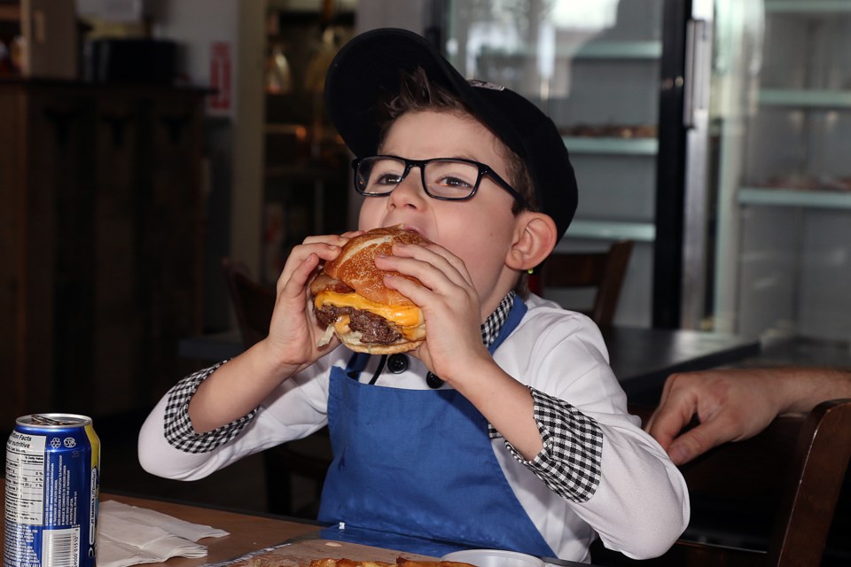 Hunter Fernyc tests out his creation, the Hunter Burger, at Beefcake's Burger Factory on Thursday, Feb. 20, 2020. (Leith Dunick, tbnewswatch.com)