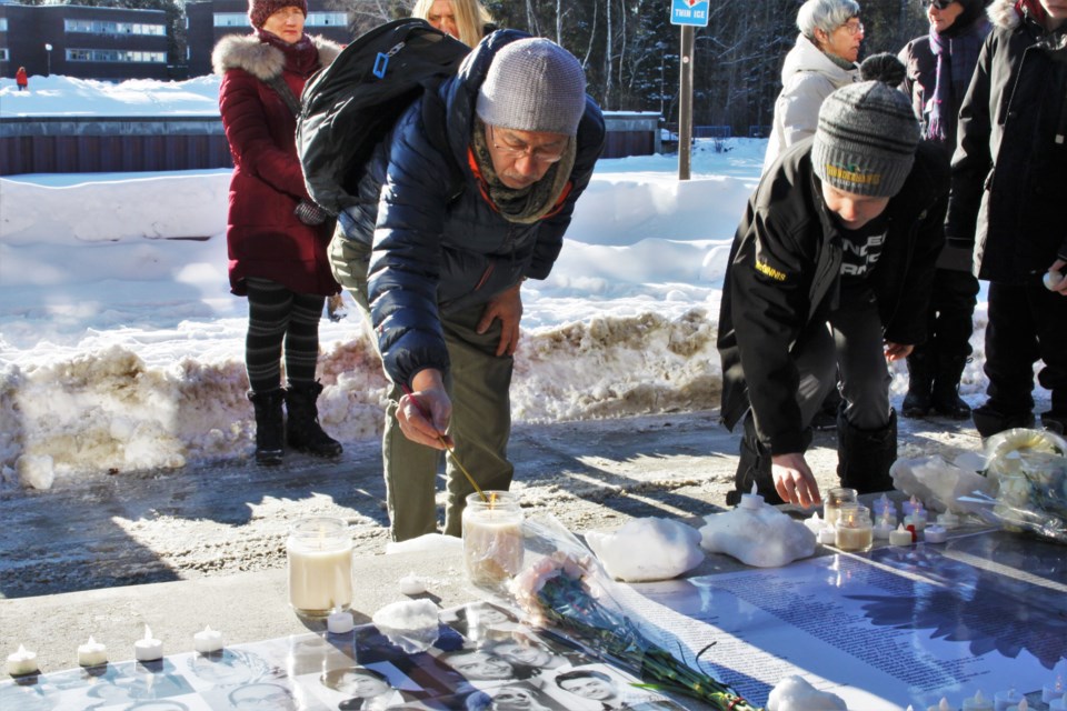 A man lights a candle in memory of victims of the Iran plane crash at Saturday's vigil. (Ian Kaufman, Tbnewswatch)