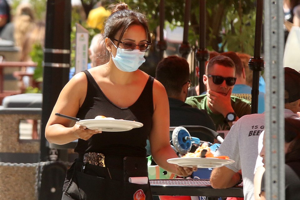 A server at Rooster's Bistro brings food to customers on Friday, July 24, 2020. (Leith Dunick, tbnewswatch.com)