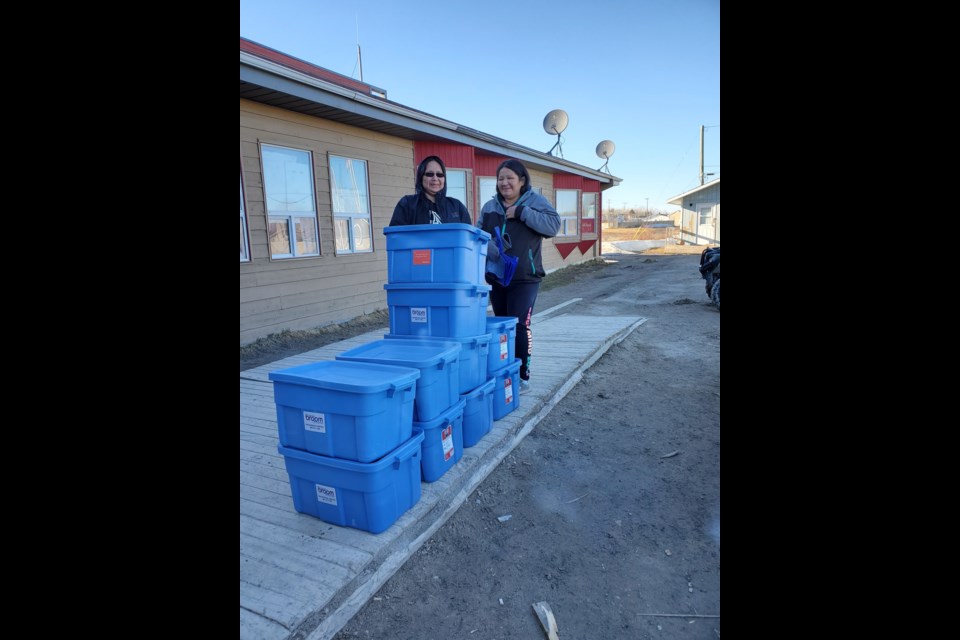 Trudy Wabassse (l) and Stacey Spence accepted some of the bins containing cleaning supplies that were delivered to Webequie (submitted photo)