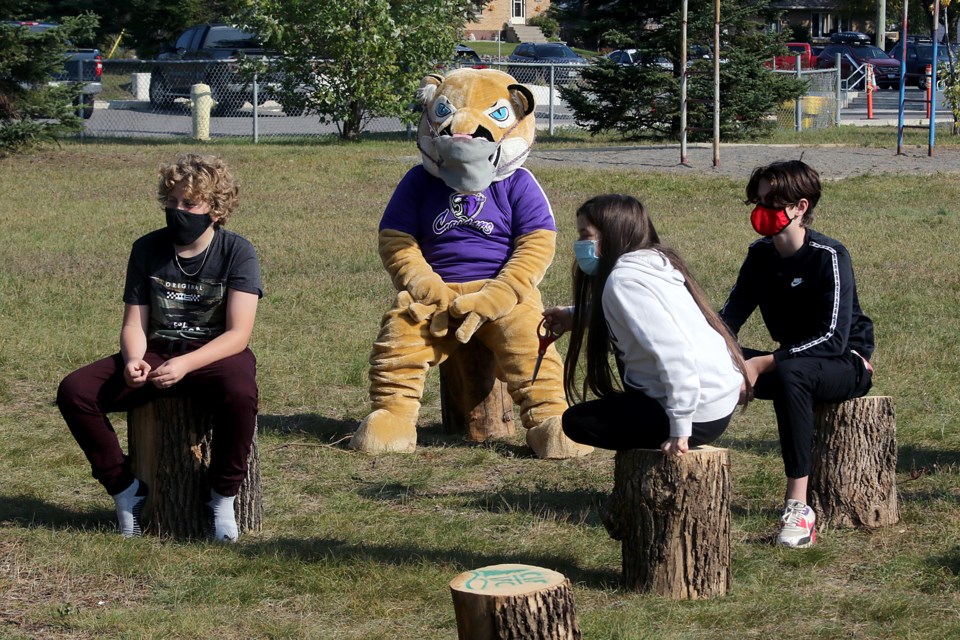 Students at Claude E. Garton Public School enjoy the start of their outdoor classroom on Monday, Sept. 21, 2020, sitting on tree stumps provided by the Northwestern Ontario section of the Canadian Institute of Forestry. (Leith Dunick, tbnewswatch.com)