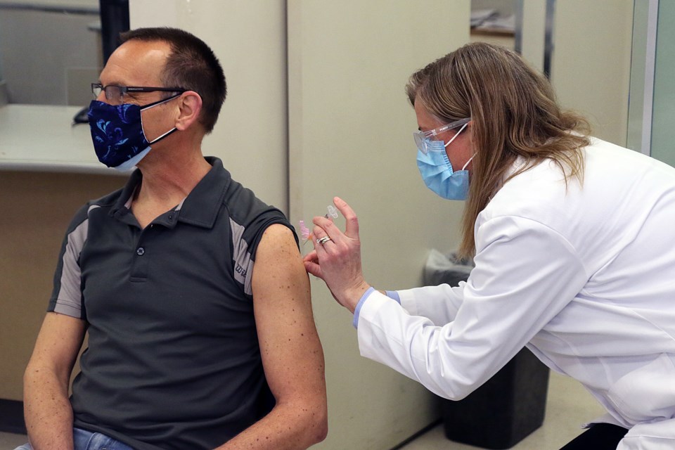 Pharmacist Maggie Willmore, owner of the Shopper's Drug Mart on Red River Road in Thunder Bay, on Thursday, April 8, 2021, adminsters a dose of the AstraZeneca Vaccine to 59-year-old Monty Peters. (Leith Dunick, tbnewswatch.com)