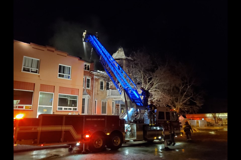 On Thursday morning, a firefighter climbed down a ladder at the front of the building, near where the iconic cupola above the main entrance collapsed Wed. night (Gary RInne/TBNewswatch)