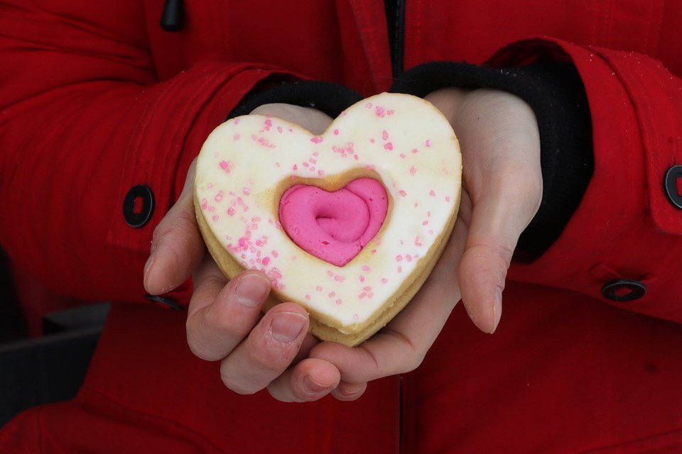 Shannon Hobbs holds a heart-shaped cookie on Thursday, Feb. 18, 2021, outside of Bay Village Coffee, which is selling the treats to raise money for the Thunder Bay Regional Health Sciences Foundation's Our Hearts at Home cardiovascular surgery campaign. (Leith Dunick, tbnewswatch.com)