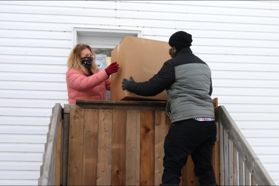 Linda Bruins, executive director of Evergreen A United Neighbourhood, accepts a donation of masks from a member of the community. (Photos by Doug Diaczuk - Tbnewswatch.com). 