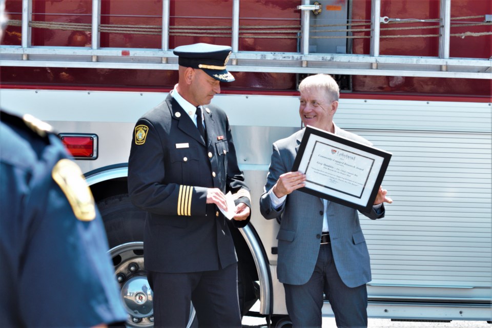 Lakehead VP of research and innovation Dr. Andrew P. Dean presents Thunder Bay fire chief Greg Hankkio with an award of excellence. (Ian Kaufman, TBNewswatch)