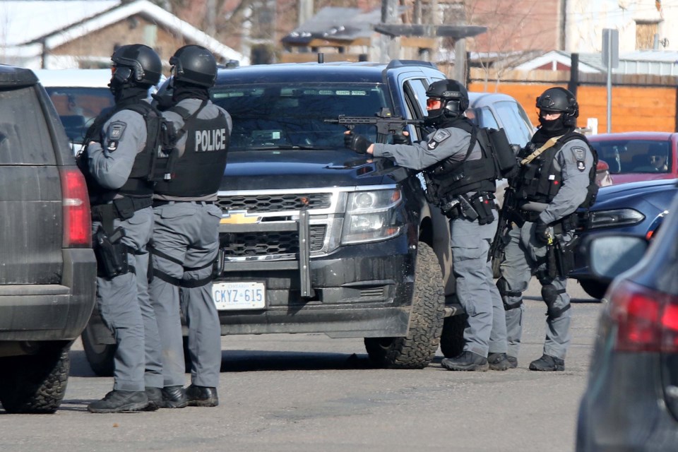 Thunder Bay Police point a gun toward a house in the 200 block of Cumming Street on Friday, March 26, 2021. (Leith Dunick, tbnewswatch.com
