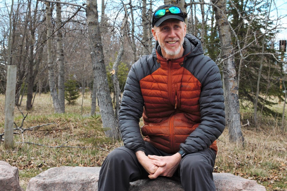 Jarron Childs, who leads the Friends of Brent Park, sits on one of the stone benches the group helped raise funds for. (Ian Kaufman, TBNewswatch)