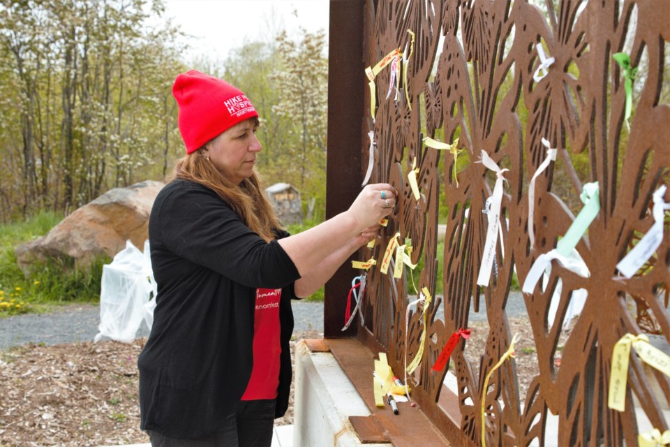 Hospice Northwest communications coordinator Kathleen Buso ties a ribbon on the butterfly wall at Boulevard Lake. (Photos by Ian Kaufman, TBNewswatch) 