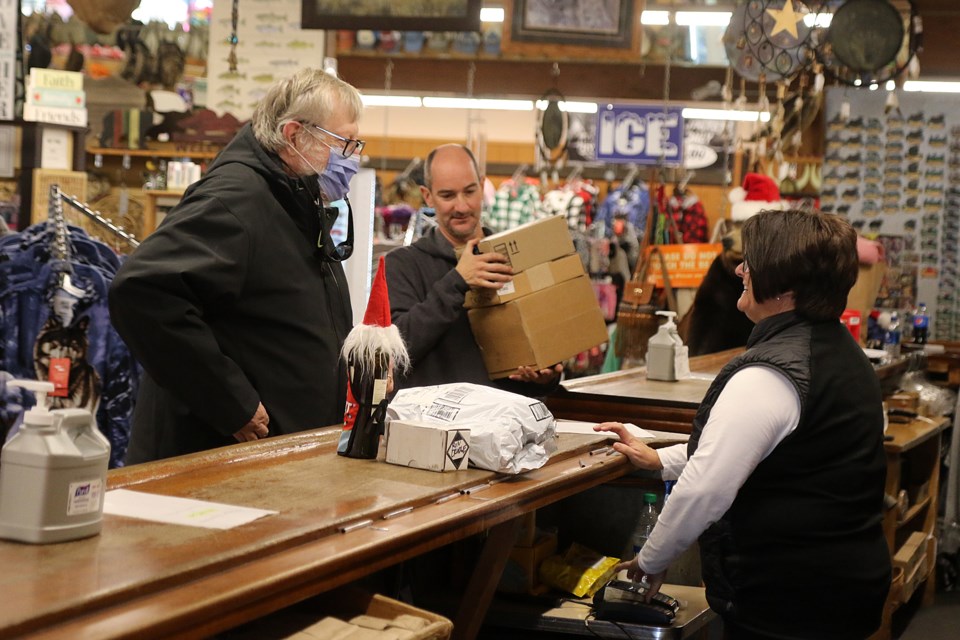 Ron Crudge (left) picks up a number of parcels on Tuesday, Nov. 30 at Ryden's Border Store from owner Lori Boomer. (Leith Dunick, tbnewswatch.com)