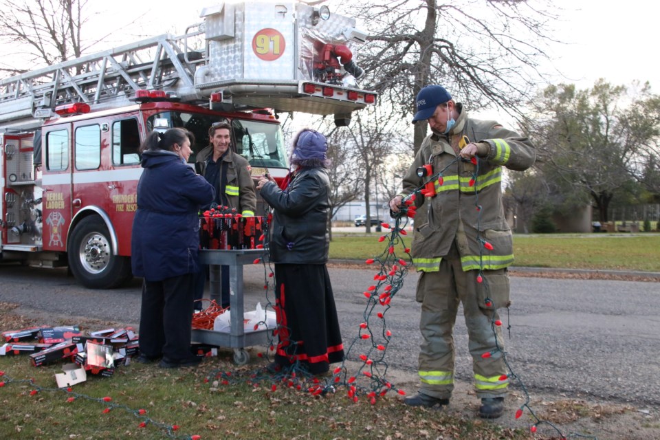 Members of Thunder Bay Fire Rescue assist Const. Sharlene Bourdeau and elder Sheila DeCorte decorate the third tree in the Tree of Hope Project. (Photos by Doug Diaczuk - Tbnewswatch.com). 