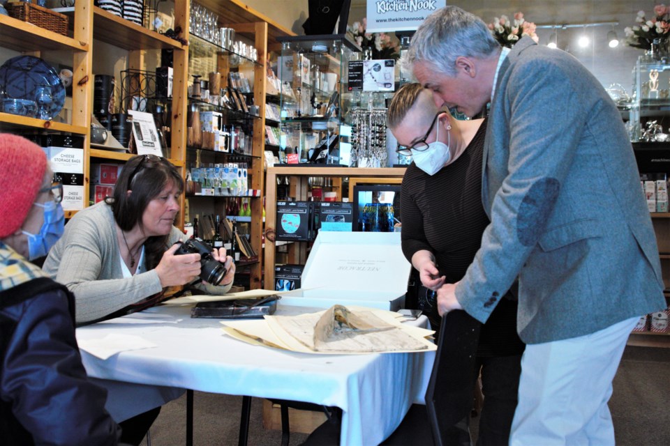 From left, historian Kathy Toivonen, Lakehead University archivist Sara Janes, and property owner Brad McKinnon examine documents from the Finnish Labour Temple's time capsule sealed in 1909. (Ian Kaufman, TBnewswatch)