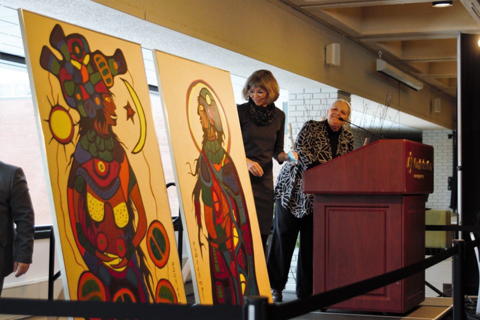 Confederation College president Kathleen Lynch (left) and Thunder Bay Art Gallery executive director Sharon Godwin look on after two Norval Morrisseau paintings were unveiled at the college on Thursday. (Photos by Ian Kaufman, TBnewswatch)