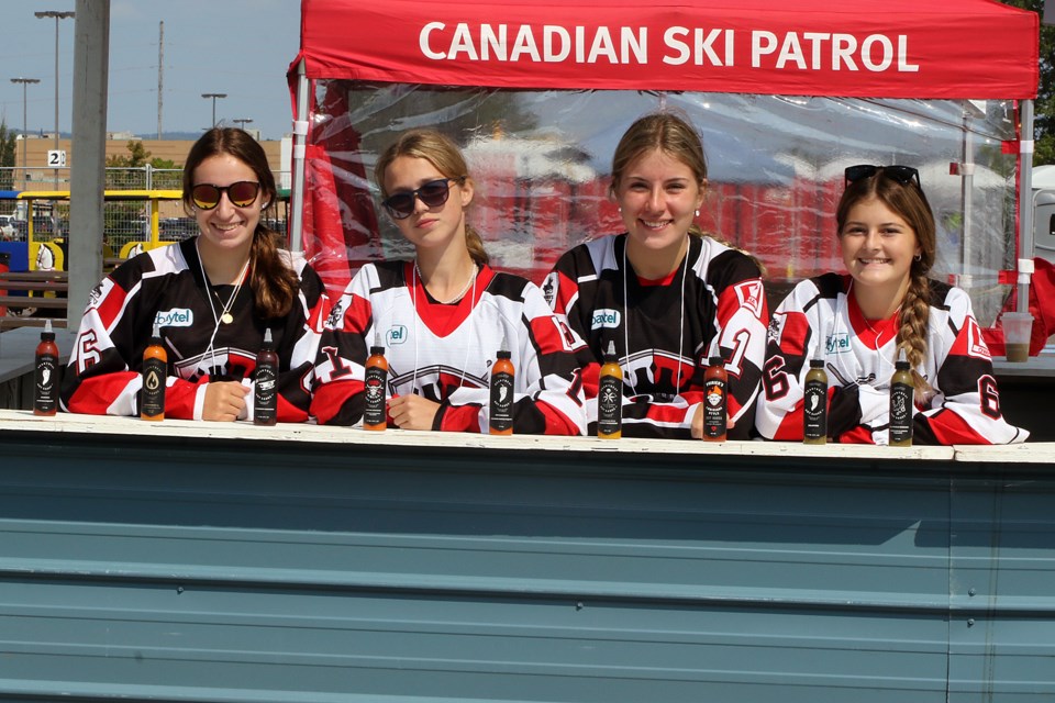 Kali Bragnalo, Annie Mallon, Keira Stokaluk and Mya Steele of the Halfway Motors U18 A Queens hockey team are selling Heartbeat Hot Sauce for $10 a bottle at the 2022 Thunder Bay Rib Fest. (Leith Dunick, tbnewswatch.com)