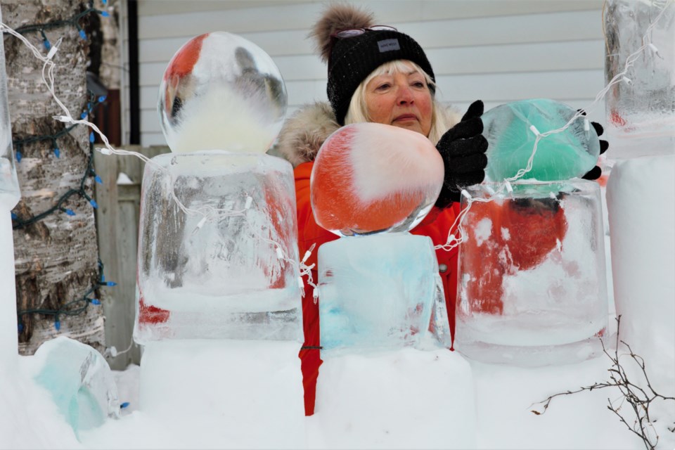 Ev Burki does some upkeep on a snow fort she has built in her front yard. (Photos by Ian Kaufman, TBNewswatch)