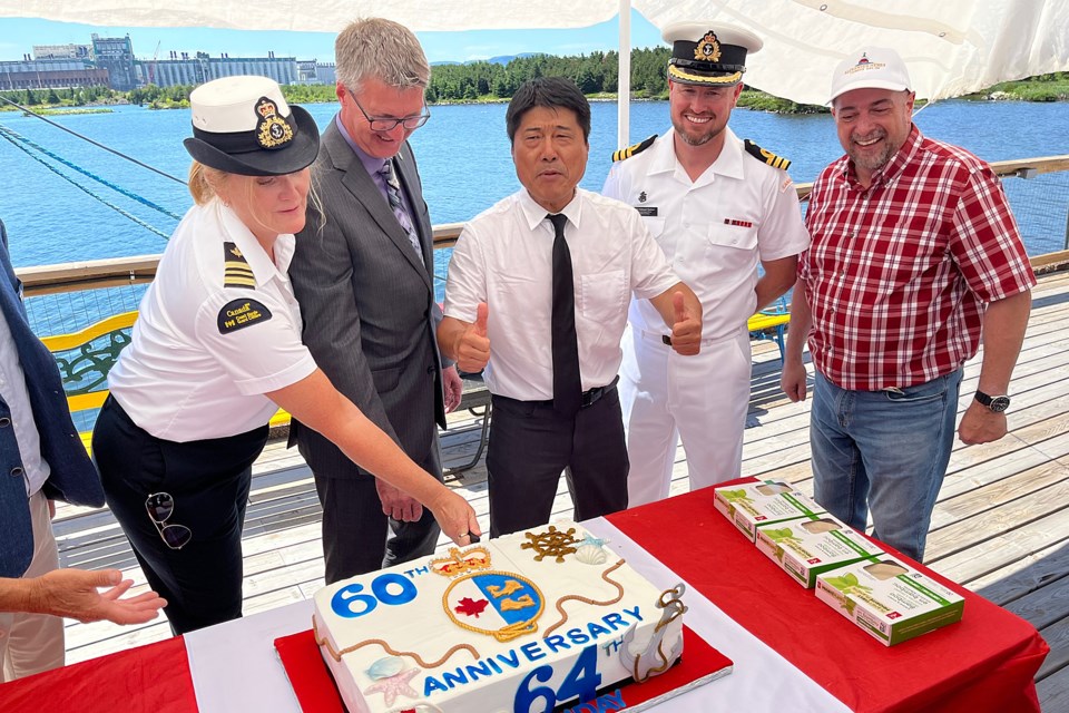 Maureen Kelly, the deputy marine superintendent for the Great Lakes sector for the Central region of the Canadian Coast Guard (from left), Thunder Bya-Atikokan MPP Kevin Holland, acting mayor Peng You, Nathaniel Moulson, commanding officer at HMCS Griffon and Rob Kilgour of the Lakehead Transportation Museum on Monday, July 18, 2022 cut a cake honouring 60 years of the Canadian Coast Guard and the 64th birthday of the Alexander Henry. (Leith DUnick, tbnewswatch.com)