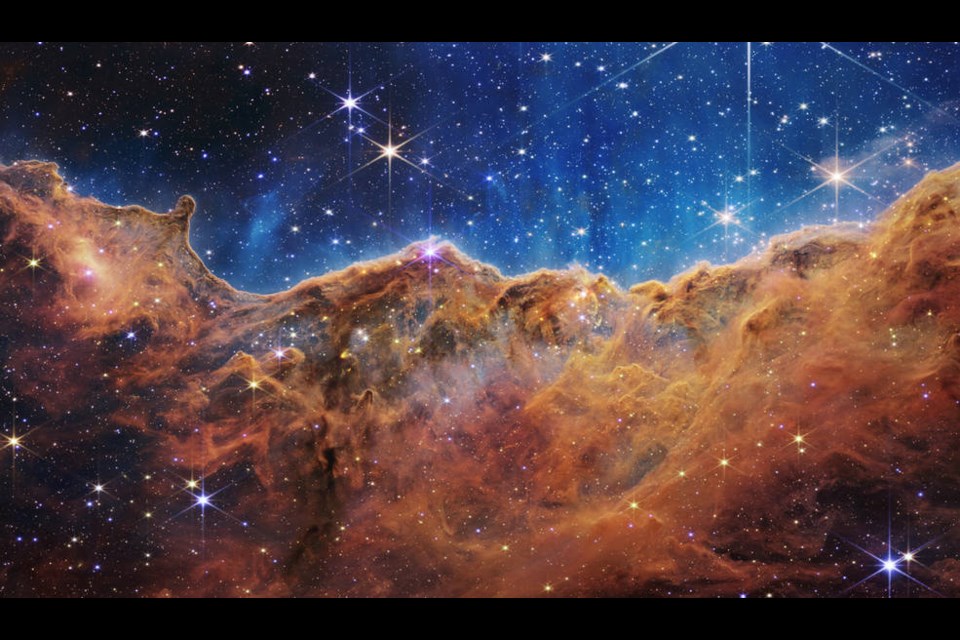 This landscape of “mountains” and “valleys” speckled with glittering stars is actually the edge of a nearby, young, star-forming region called NGC 3324 in the Carina Nebula. Captured in infrared light by NASA’s new James Webb Space Telescope, this image reveals for the first time previously invisible areas of star birth.