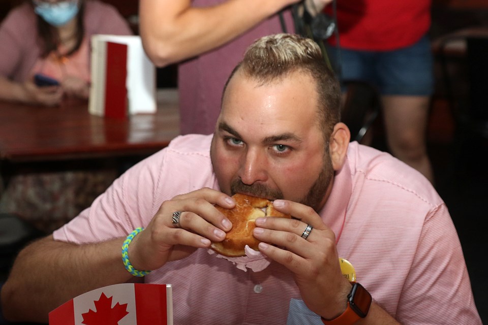 Jason Veltri takes his first bites on Friday, July 1, 2022, taking part in the Red Lion Smokehouse's Canada Day Persian Eating Contest. (Leith Dunick, tbnewswatch.com)