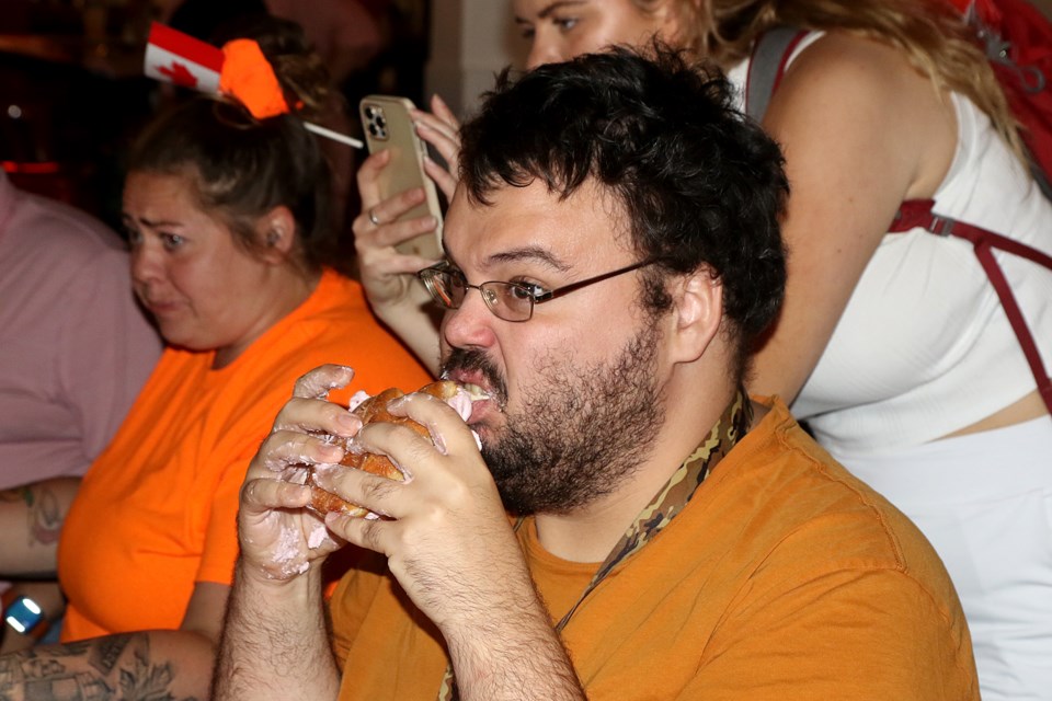 Thomas Currie uses his patented sandwich technique to win a third Canada Day Persian Eating Contest at the Red Lion Smokehouse. (Leith Dunick, tbnewswatch.com)