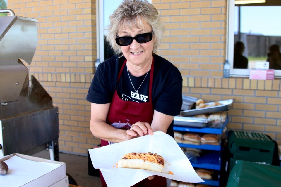 Dew Drop Inn volunteer Eileen Dettbarn serves up the classic Dewy Dog at the United Way of Thunder Bay CommUNITY B.B.Q. on Thursday. (Photos by Doug Diaczuk - Tbnewswatch.com). 