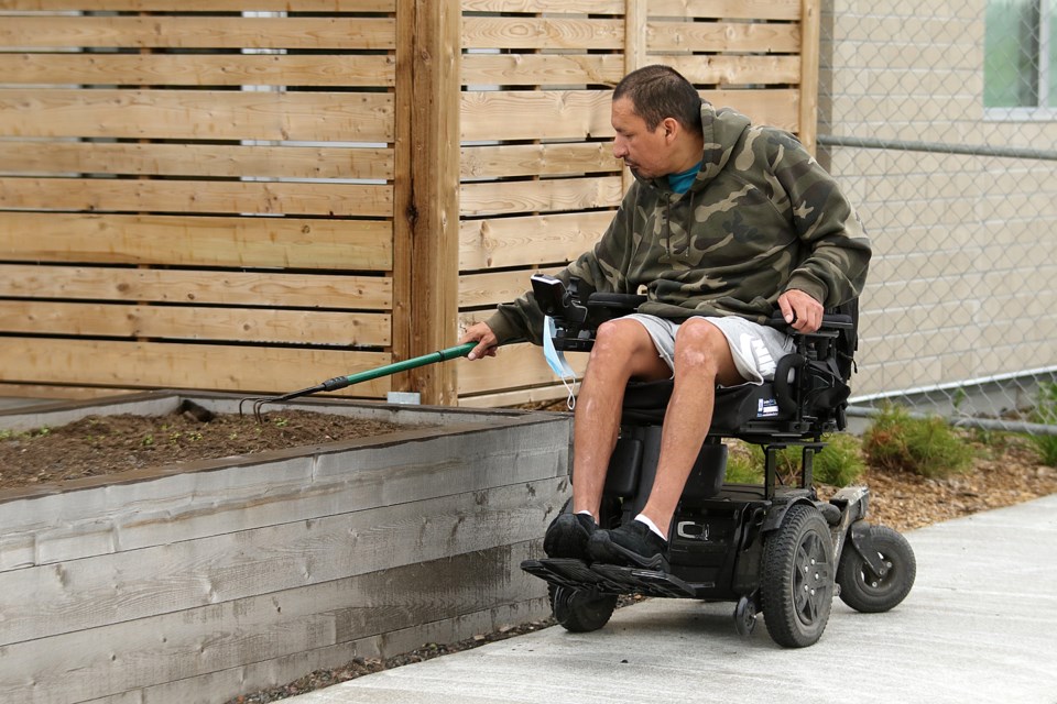 A resident prepares the soil in a planting bed at the Salvation Army's Field of Greens community garden on Monday, June 6, 2022. (Leith Dunick, tbnewswatch.com)