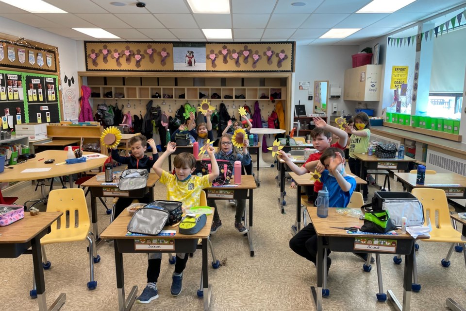 Grade 2 students proudly show off their sunflowers