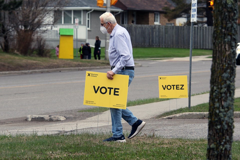 An Elections Ontario worker puts up a voting sign outside the Thunder Bay 55 Plus Centre on Thursday, May 19, 2022. (Leith Dunick, tbnewswatch.com)