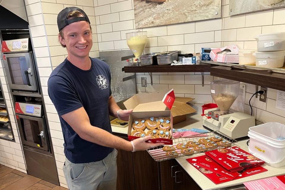 Thunder Bay Fire Rescue firefighter Robert Sheppard displays Smile Cookies he helped decorate on Thursday, Sept. 22, 2022 at the Tim Hortons location on River Street. (Leith Dunick, TBnewswatch)