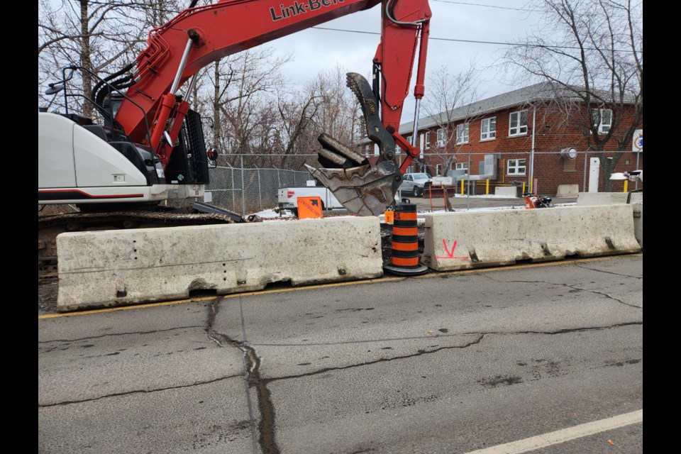 An excavator is digging up the pavement on Algoma Street near HMCS Griffon, where a storm sewer requires repairs (TBnewswatch)