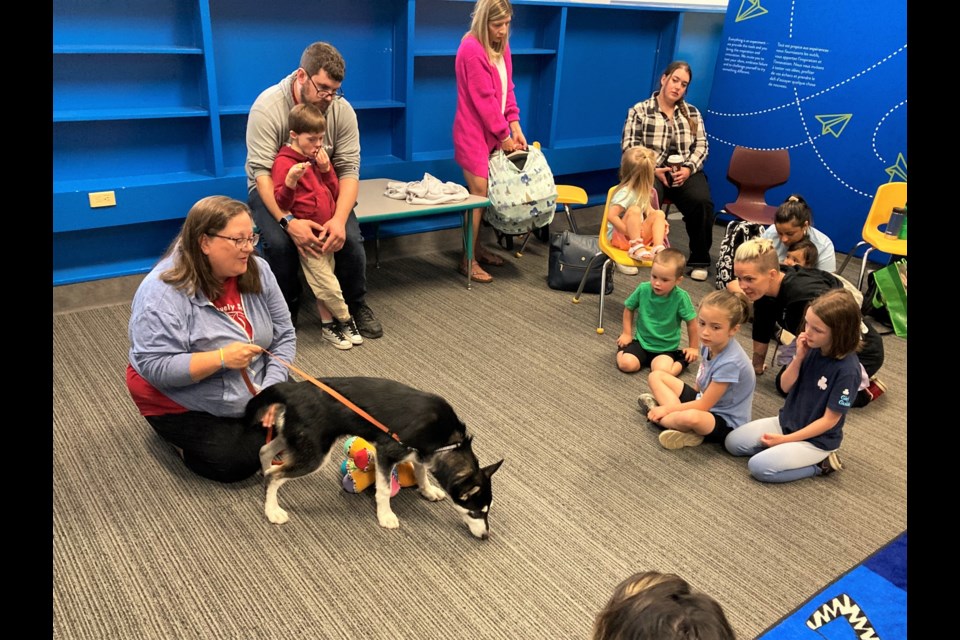 Dog trainer Tammy Williams with Husky mix Oakley at a puppy storytime event at the Brodie Library on Tuesday.