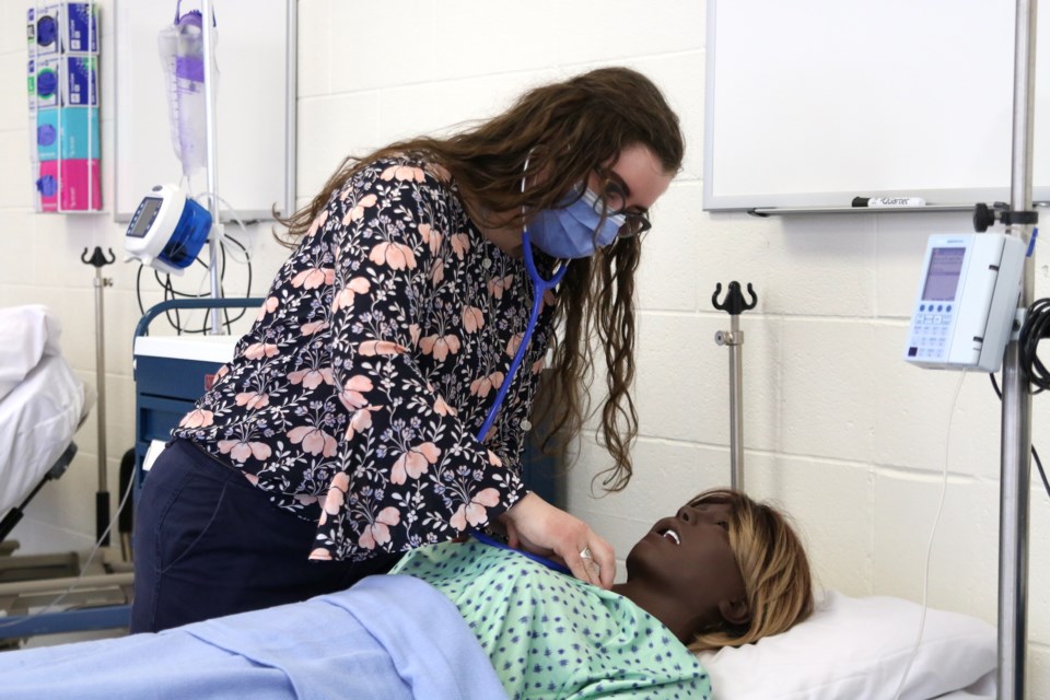 Third-year nursing student, Erin Hamilton, practices her skills on one of the patient mannequins in the new Lakehead University nursing lab. 