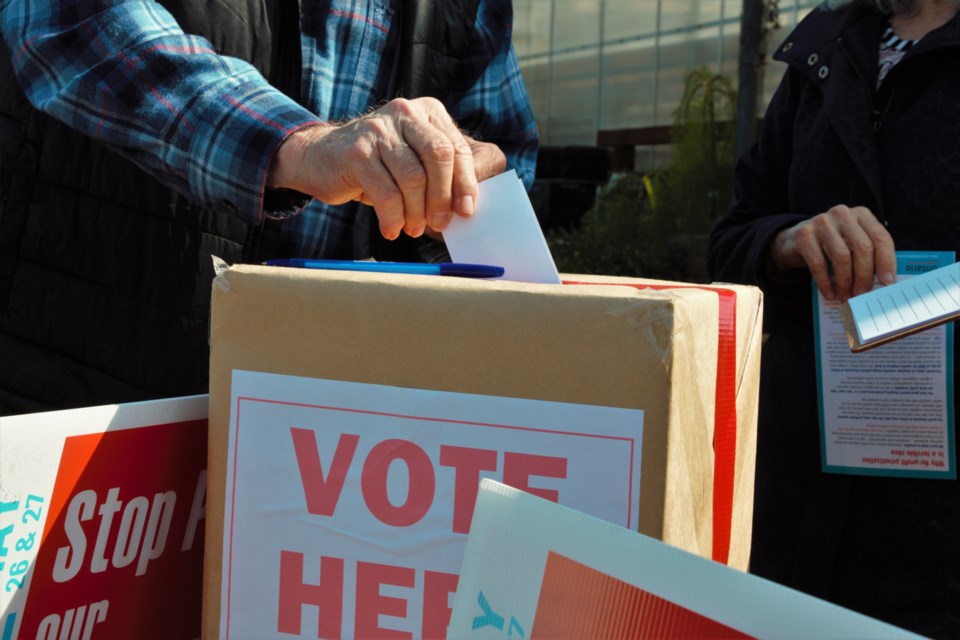 A Thunder Bay resident casts a ballot in a 'people's referendum' campaign organized by the Ontario Health Coalition. (Photos by Ian Kaufman, TBnewswatch)