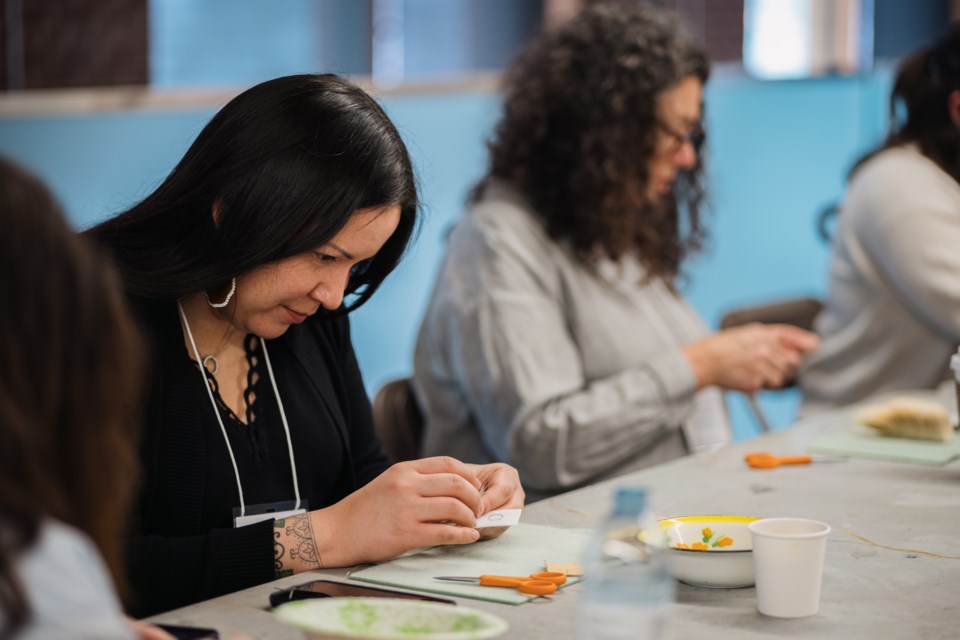 Artist Katie Longboat works on beading during Aanikoobijiganag: Thunder Bay Beading Symposium in February. 