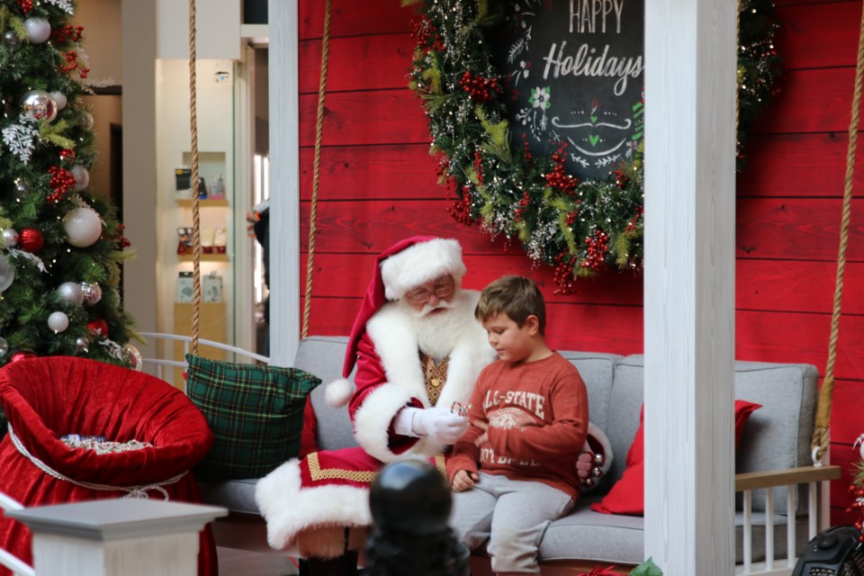 Kenny Burrows visits the mall to take pictures with Santa Claus with his parents.