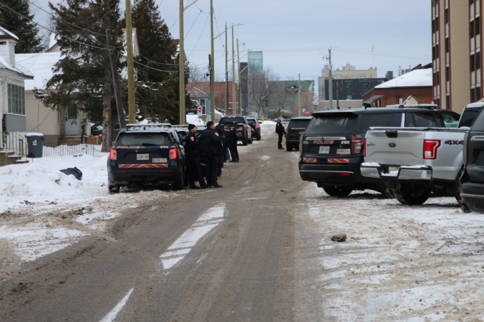 Police stand armed outside the building.