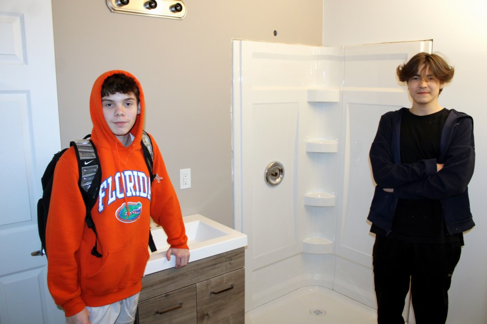 Hammarskjold High School Grade 10 students Zach Poulin, left, and Daniel Wassaykeesic show some of the work they did on a modular home project.