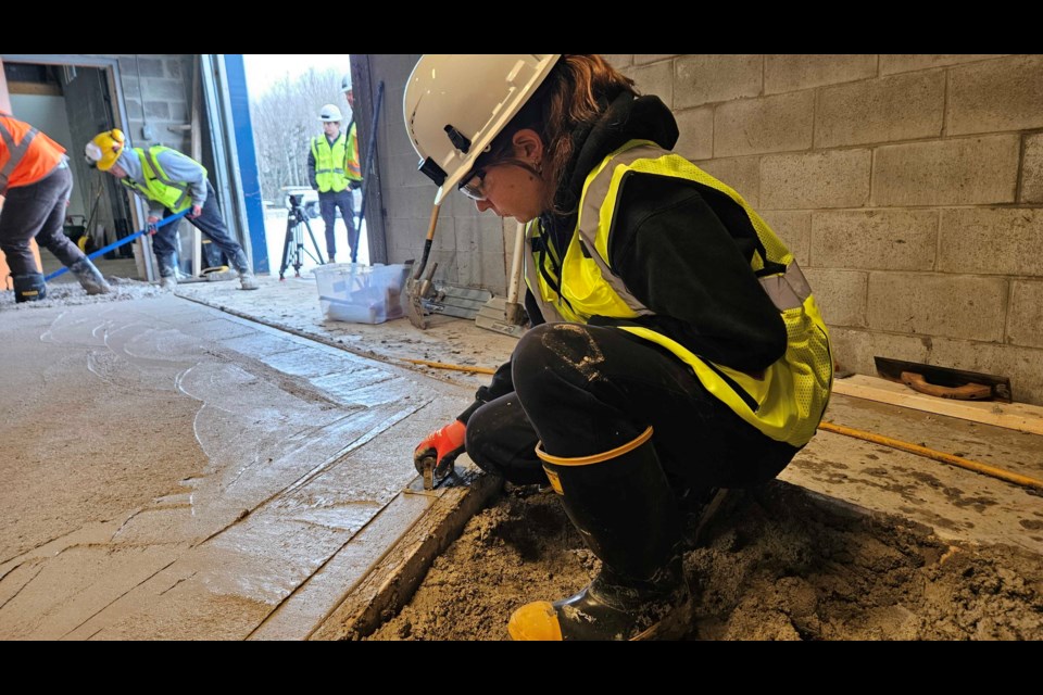 An apprentice is working with a new reusable concrete material that hardens after approximately three weeks, giving more training time for those looking to learn. 