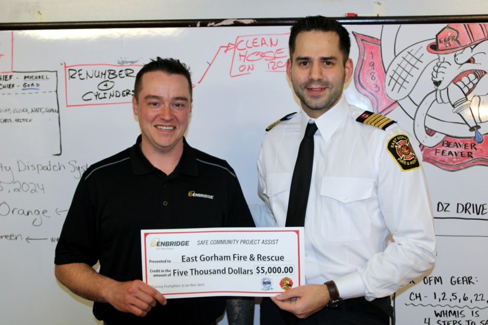 Joseph Beg of Enbridge Gas presents East Gorham Fire & Rescue chief Michael Heringer with a donation of $5,000 on Wednesday evening.