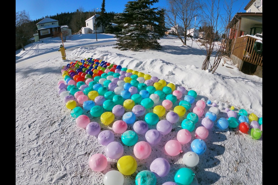 Derek Thomson, Candace Deschamps, and five-year-old Lilia Deschamps froze nearly 300 water-filled balloons (Abraxan Canada/Facebook)
