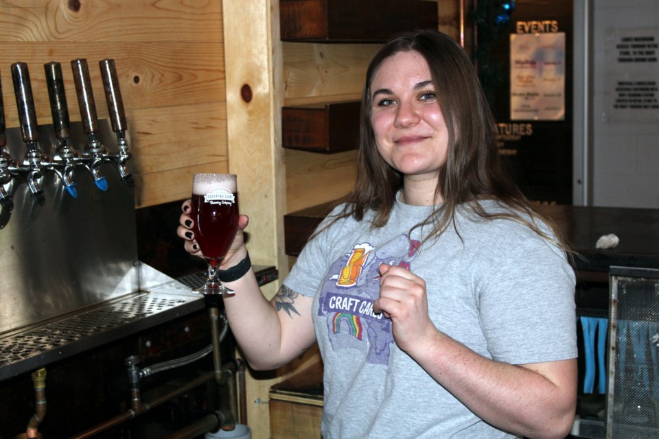 Sleeping Giant Brewing Company sales representative Erin Cuma showcases the Craft Cares fruited hazy ale that is being sold during the company's annual charitable campaign.