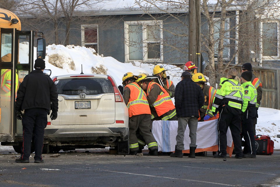 Thunder Bay Police, paramedics and Thunder Bay Fire Rescue crews investigate a crash involving an SUV and a school bus on Friday, Feb. 21, 2025 at the intersection of High Street North and River Street. (Leith Dunick, tbnewswatch.com)