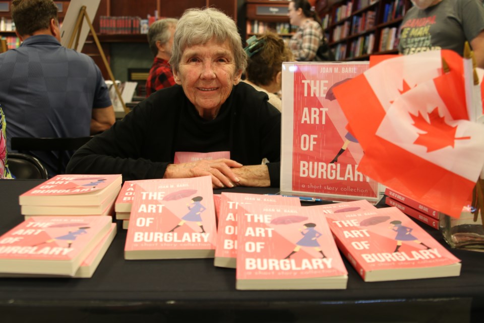 Twelve authors stop at Indigo Thunder Bay to display, sell and sign their books for its First Annual Local Author Showcase on July 19. Joan Baril, one of the authors, displays her book “The Art of Burglary.” She says it’s done very well and has been a lot of fun to publish.