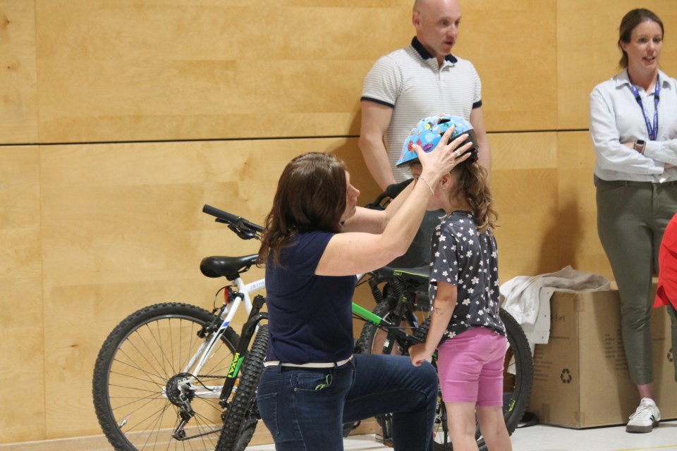 A student getting fitted to make sure the helmet fits.