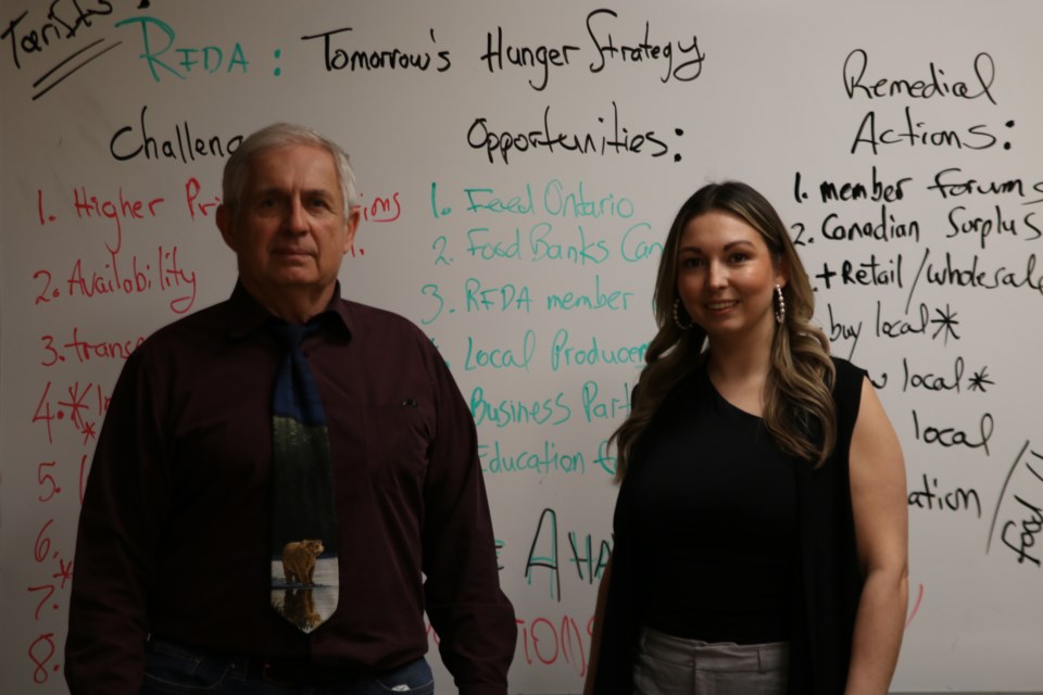 The Regional Food Distribution Association's (RFDA) executive director, Volker Kromm, left, and April Mercier, the RFDA’s office manager, right, discuss what tariffs could mean for the organization.
