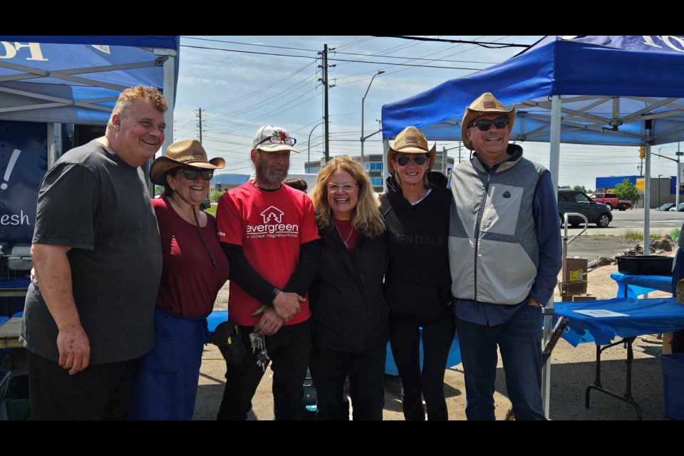 Ron LeMarquand and his wife Lisa; a volunteer with Evergreen a United Neighbourhood's Marc Blais and Linda Bruins; and Stacy and Tyler Dolcetti, the owners of Dominion Motors, stand together for the charity barbecue.